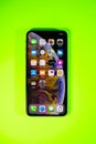 Apple iPhone Xs Max against vibrant green background