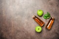 Apple juice in a bottle, green apple and fresh mint leaves on a dark rustic background. Top view, flat lay, copy space