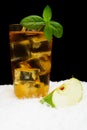 Apple juice,ice cubes and apple with mint on black on snow Royalty Free Stock Photo