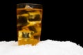 Apple juice with ice cubes on black on ice Royalty Free Stock Photo