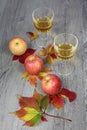 Apple juice, three apples and autumn leaves