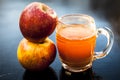 Apple juice in a transparent glass with two raw apples in  side,close up view Royalty Free Stock Photo
