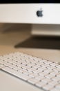 Apple keyboard with blurred monitor in the background