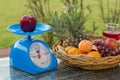 Apple on kitchen scale with fruits in basket an wine glass Royalty Free Stock Photo