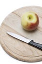 Apple and knife on wooden plate over white background Royalty Free Stock Photo