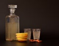 Apple liqueur with spices on a black background, homemade alcohol in a crystal decanter and two glasses, cinnamon sticks, anise Royalty Free Stock Photo