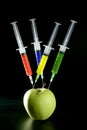 Apple manipulation with syringes Royalty Free Stock Photo