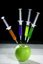 Apple manipulation with syringes Royalty Free Stock Photo