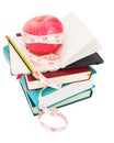 Apple with measure tape on big pile of books Royalty Free Stock Photo