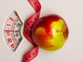 Apple with measuring tape on weight scale. Dieting Royalty Free Stock Photo