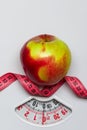 Apple with measuring tape on weight scale. Dieting Royalty Free Stock Photo