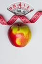 Apple with measuring tape on weight scale. Dieting Royalty Free Stock Photo