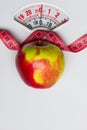 Apple with measuring tape on weight scale. Dieting Royalty Free Stock Photo