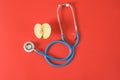 an apple and a medical stethoscope on a bright red background Royalty Free Stock Photo
