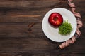 An apple with microgreen on an empty white plate with a tape measure to measure the figure. Diet and raw food concept.