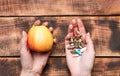 Apple natural food and dietary supplements in capsules in female hands wooden background, vitamins Royalty Free Stock Photo