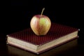 Apple on Old Book on a Polished Wooden Shelf Royalty Free Stock Photo