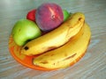 Apple, peach and banana on orange plate Royalty Free Stock Photo