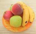 Apple, peach and banana on orange plate Royalty Free Stock Photo