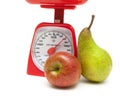 Apple, pear and kitchen scale on white background Royalty Free Stock Photo