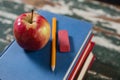 Apple, pencil and eraser on stack of books Royalty Free Stock Photo