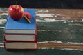 Apple, pencil and eraser on stack of books Royalty Free Stock Photo