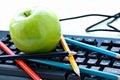 Apple and pencils lying on the keyboard Royalty Free Stock Photo