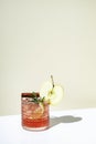 Apple pie alcoholic cocktail drink with vodka, apple liqueur, cinnamon, lemon, garnished with rosemary. Light beige background, Royalty Free Stock Photo