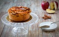 Apple pie on crystal cake plate on wooden table
