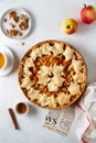 Apple pie decorated with dough stars on white table, top view