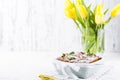 Apple pie in dishes on a white background and a bouquet of spring yellow tulips. Homemade pastries with fruit for a delicious