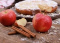 Apple pie - fresh apples and cinnamon sticks in front of a homemade apple pie on a rustic wooden table Royalty Free Stock Photo