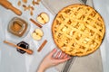 Apple pie on a gray kitchen towel. Hands put on the table. Apples, cinnamon, sugar, honey and nuts, top view Royalty Free Stock Photo