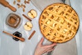 apple pie on a gray kitchen towel. Hands put on the table. Apples, cinnamon, sugar, honey and nuts, top view Royalty Free Stock Photo