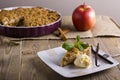 Apple pie with ice cream, decorated with vanilla, mint and cinnamon on wooden background. A delicious piece of cake with ice. Royalty Free Stock Photo