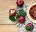 Apple pie on a plate with fresh red apples from the garden, delicious summer baked fruitcake flat on the rustic wooden table