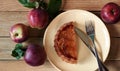 Apple pie on a plate with fresh red apples from the garden, delicious summer baked fruitcake flat on the rustic wooden table