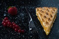 Apple pie slice on black table with currant and strawberry Royalty Free Stock Photo