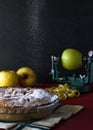 Apple pie with sugar rain. Black background with apples.