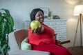 Plus size african american woman showing an apple in her hand