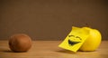 Apple with post-it note laughing on kiwi