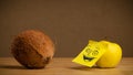 Apple with post-it note smiling at coconut