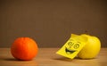 Apple with post-it note smiling at orange