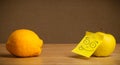 Apple with post-it note sticking out tongue to lemon