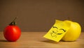 Apple with post-it note sticking out tongue to tomato