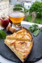 Apple products of Normandy, homemade baked apple cake, glass of cider drink and houses of Etretat village on background, Normandy