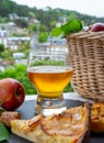 Apple products of Normandy, homemade baked apple cake, glass of cider drink and houses of Etretat village on background, Normandy