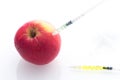 Apple with punched needles and syringes as a concept for modified food white background Royalty Free Stock Photo