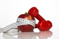 Apple and red colored dumbbells tied with a measuring tape Royalty Free Stock Photo