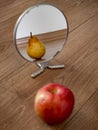 Apple reflection in mirror as pear